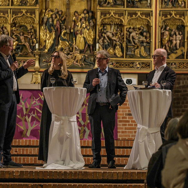 Eine Diskussion in einer Kirche mit vielen Besucherinnen und Besuchern