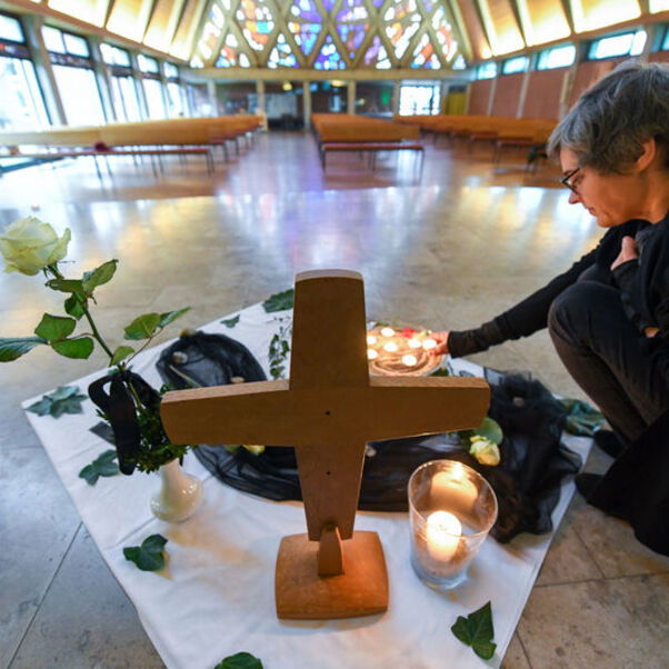 Pastorin Franziska Oberheide entzündet eine Kerze zum Gedenken im Innenraum der Corvinus-Kirche in Wunstorf