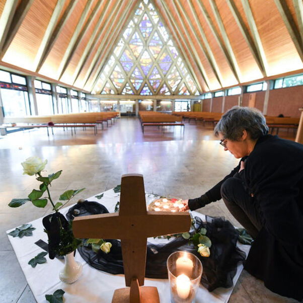 Pastorin Franziska Oberheide entzündet eine Kerze zum Gedenken im Innenraum der Corvinus-Kirche in Wunstorf