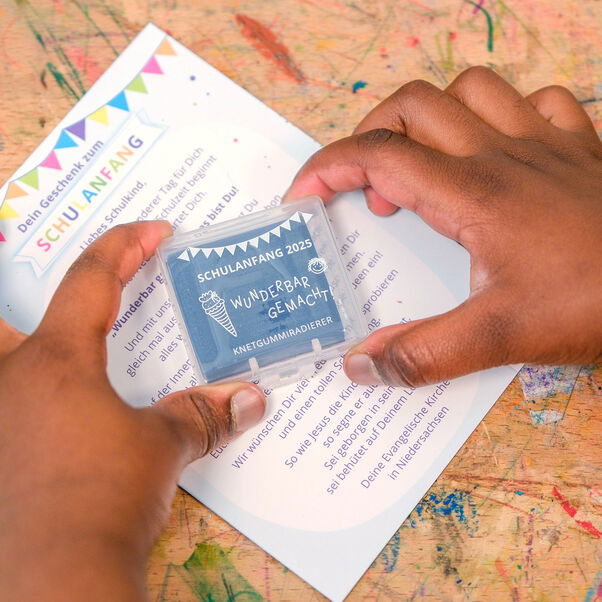 Zwei Hände halten ein Päckchen mit Radierknete.