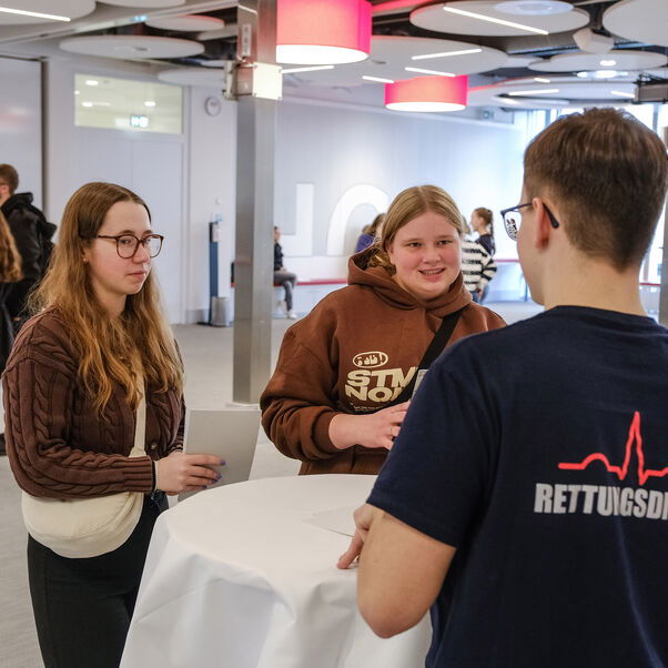 Menschen tauschen sich aus an einem Stehtisch