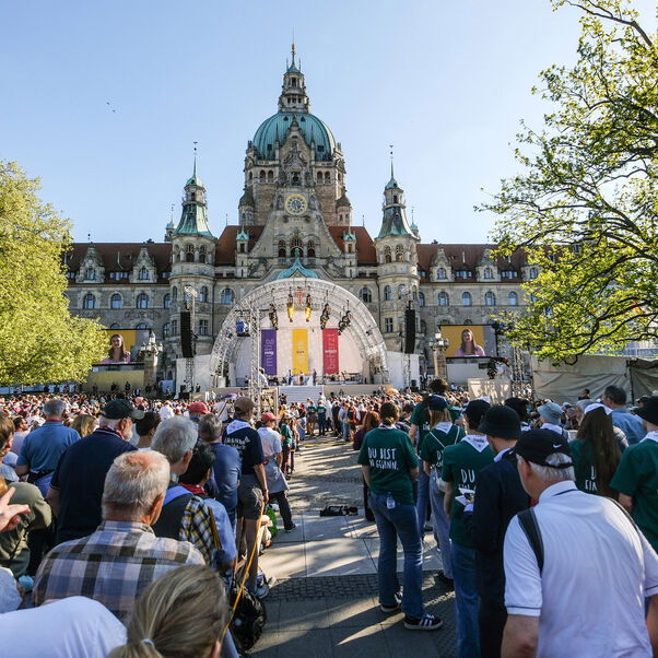 Blick aus einer Menschenmenge auf die Bühne vor dem Neuen Rathaus in Hannover.