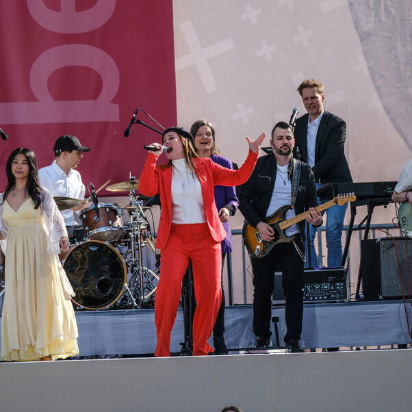 Musikerinnen und Musiker machen Musik auf einer Bühne.