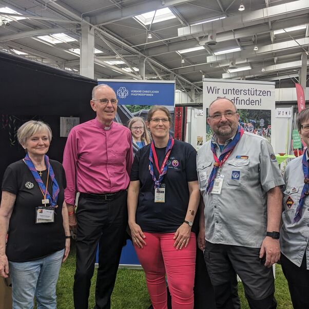 Eine Gruppe von weiblich und männlich zu lesenden Personen hat sich im Halbkreis für ein Foto aufgestellt.