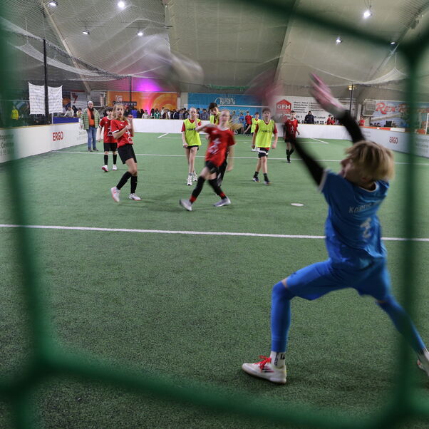 Szene bei einem Fußball-Spiel mit jungen Menschen: der Torhüter kann den Ball nicht mehr erreichen.