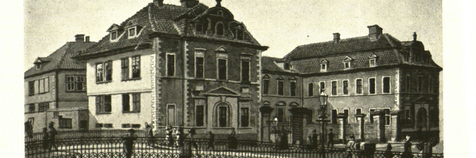 Das Bild zeigt eine schwarzweiße Zeichnung eines zweigeschössigen Gebäudes in klassizistischem Stil. 