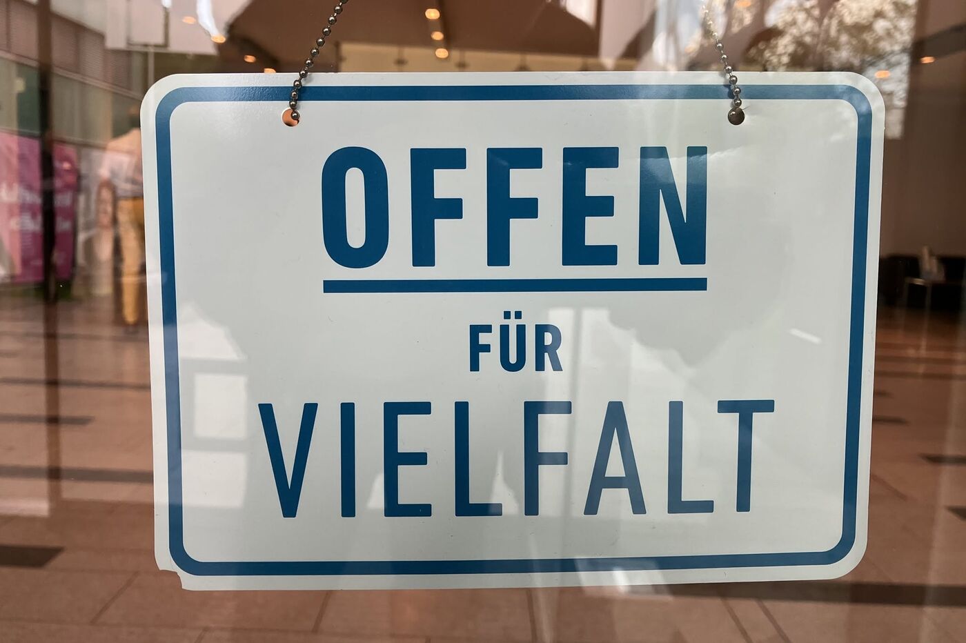 Das Bild zeigt ein Schild an einer Ladentür. Es trägt den Schriftzug "Offen für Vielfalt"