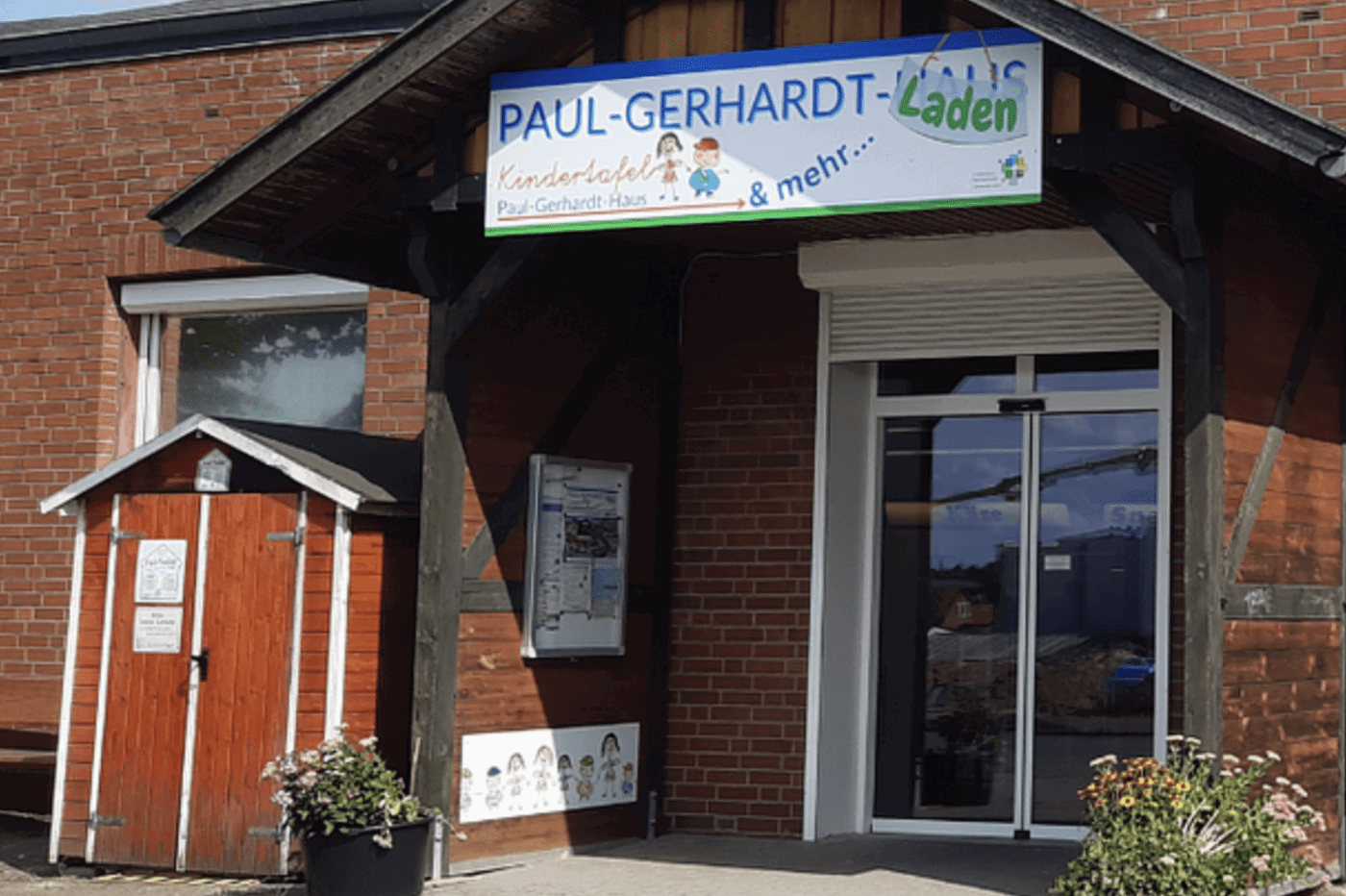 Ein Haus mit einem Schild auf dem Paul-Gerhardt-Laden und Kindertafel steht.