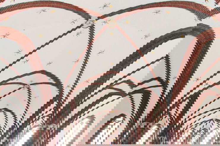 Eine mit Sternen verzierte Gewölbedecke in einer Kirche.