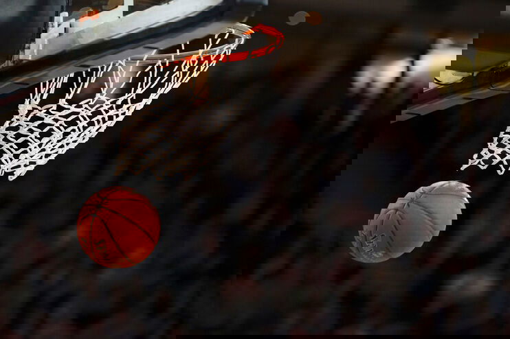 Ein Ball fällt durch einen Basketballkorb.