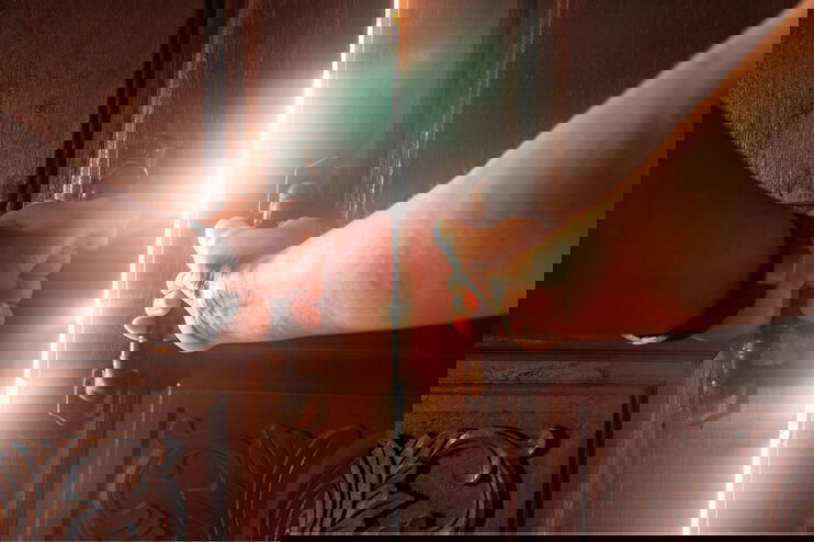 Zwei Hände öffnen eine Tür. Durch den offenen Türspalt dringt Sonnenlicht.