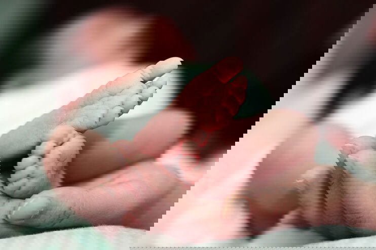 Neugeborenes in einer Hand