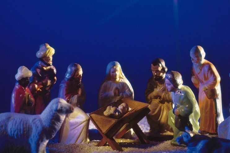 Figuren eines Krippenspiels vor blauem Hintergrund