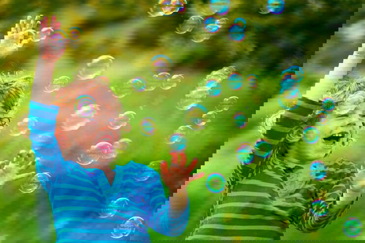 Ein Kind erfreut sich an Seifenblasen.