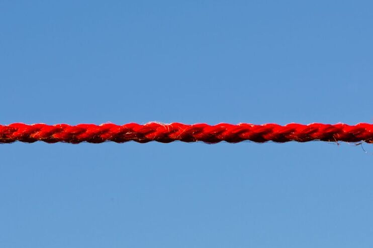 Ein rotes Seil vor blauem Himmel.