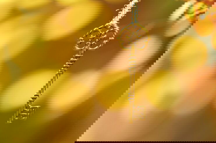 Ein goldener Schlüssel vor goldenem Hintergrund.