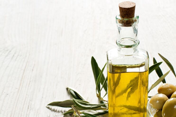 Eine Karaffe Öl und Oliven.