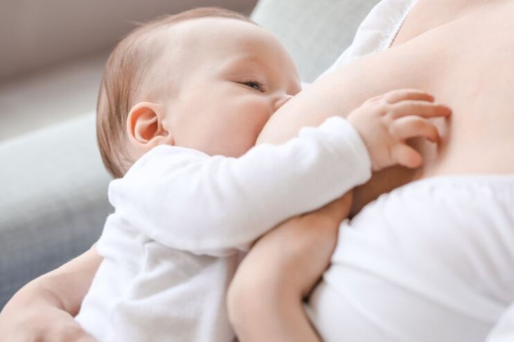 Ein Baby trinkt an einer Brust.