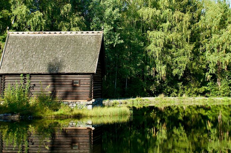 Eine kleine Hütte am Waldrand an einem See