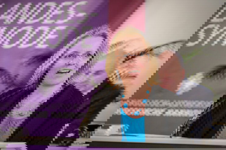 Eine weiblich lesbare Person an einem Rednerpult