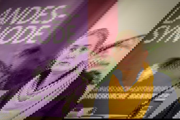 Eine weiblich lesbare Person an einem Rednerpult