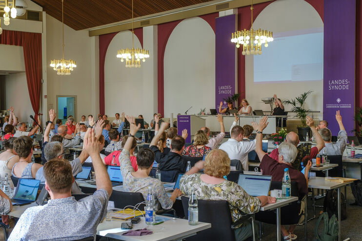 Viele Personen heben die Hand zur Abstimmung