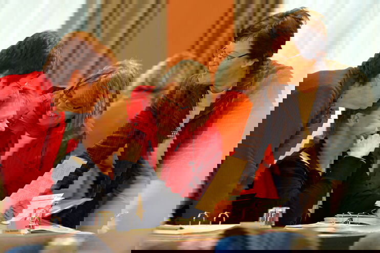 4 Frauen betrachten ein Faltblatt