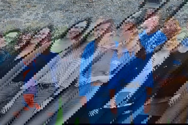 Eine Gruppe junger Frauen steht vor einem Kirchengebäude