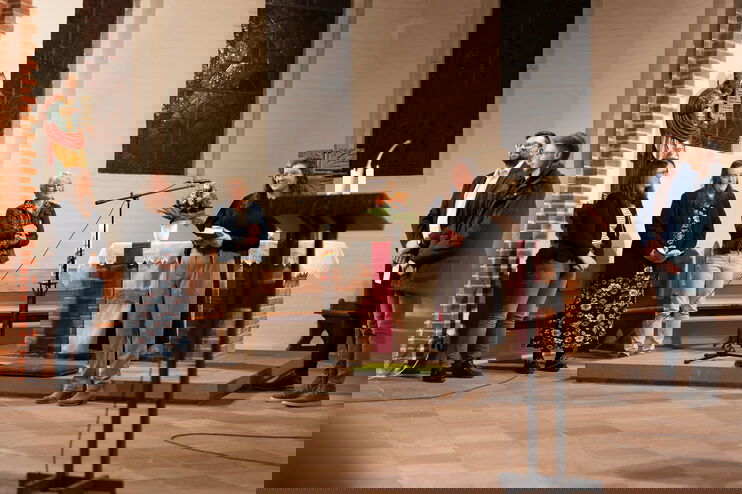 Mehrere Menschen stehen im Altarraum um eine junge Frau.