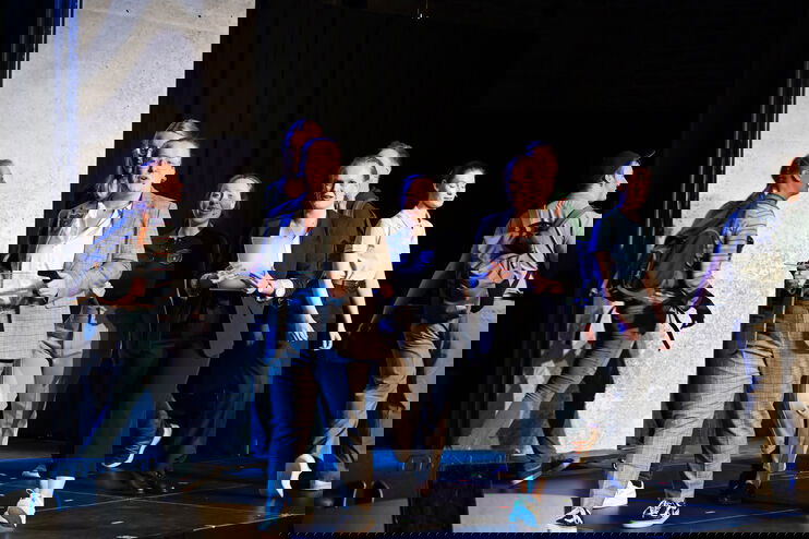 Mehrere junge Menschen gehen eine Musical-Bühne in einer Kirche entlang.