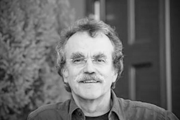 Ein schwarz-weiß Bild eines Mannes mit Schnauzbart und Brille.