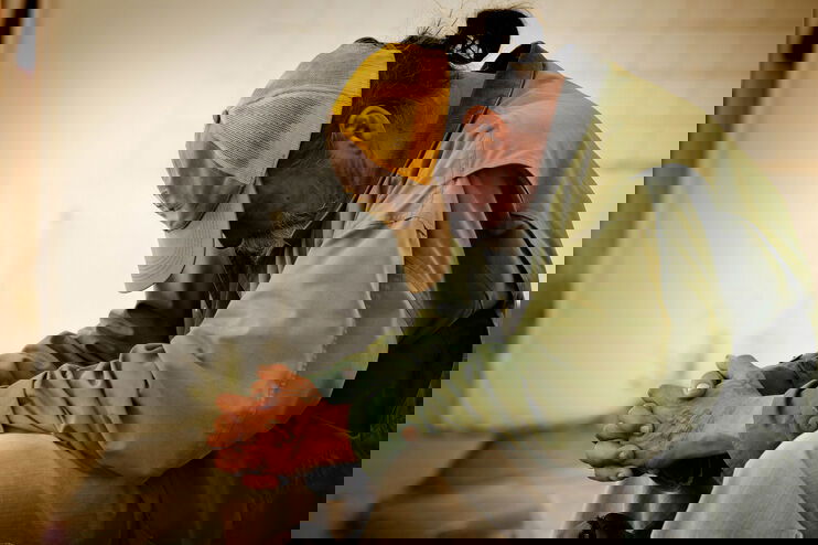 Ein Obdachloser sitzt in sich zusammengekauert.