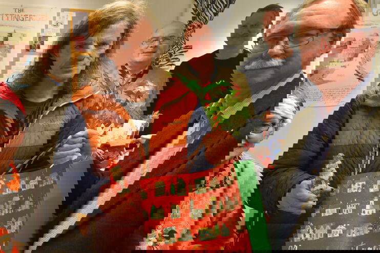 eine Gruppe von Menschen mit Weihnachtstüten und Weihnachtsmützen