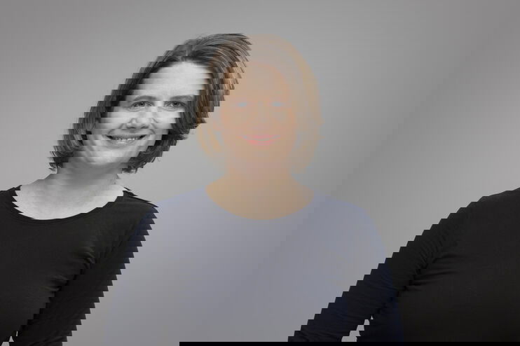 Portrait einer jüngeren Frau im schwarzen Oberteil.