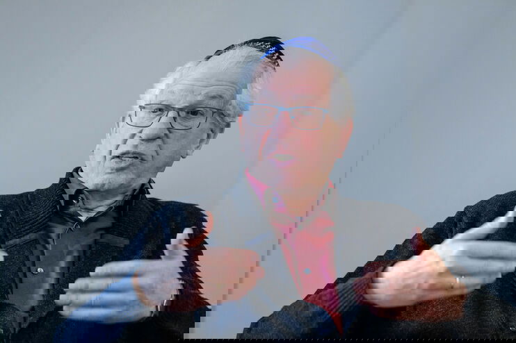 Ein älterer Mann mit Kippa spricht und gestikuliert dabei.