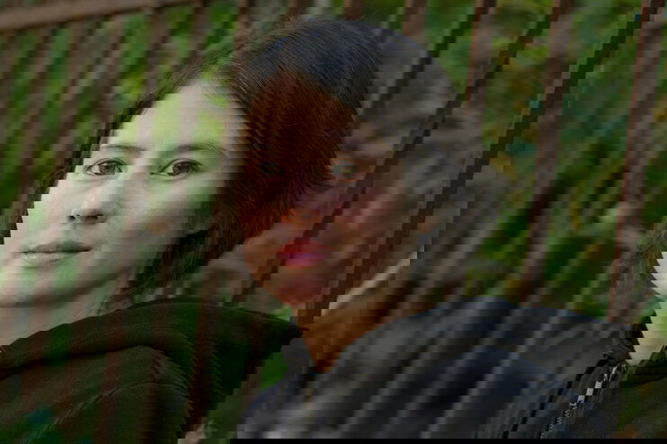 Eine junge Frau vor grünem Hintergrund.