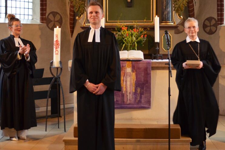 eine Gruppe von Menschen in schwarzen Talaren in einer Kirche.