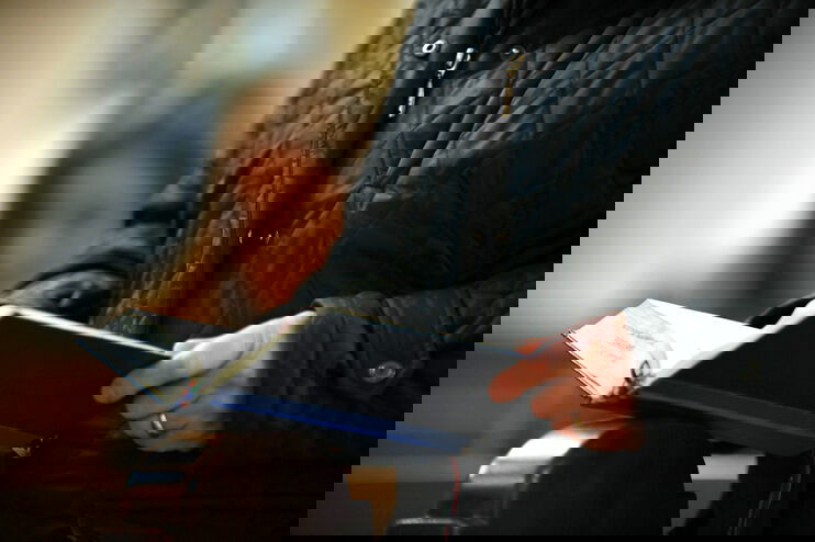 Eine Person hält ein Gesangbuch in der Hand.