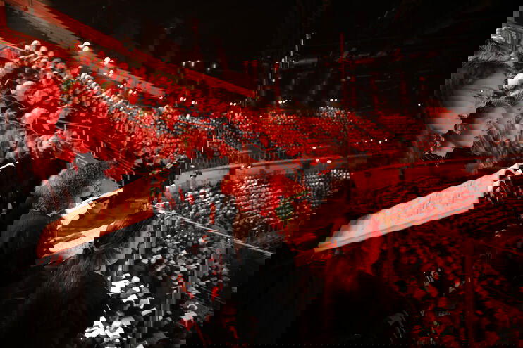 Viele junge Chorsängerinnen und -sänger singen in einem Stadion.