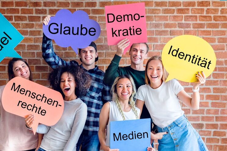 Junge Menschen halten Sprechblasen hoch.