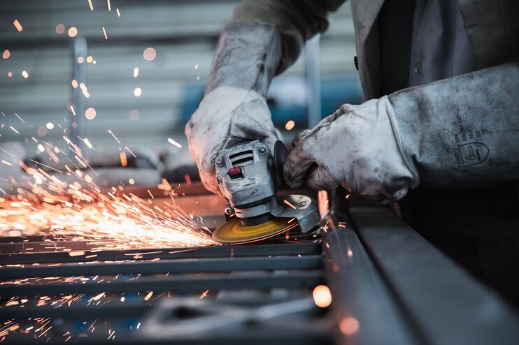 Eine Person erledigt Schweißarbeiten, es sprühen Funken.