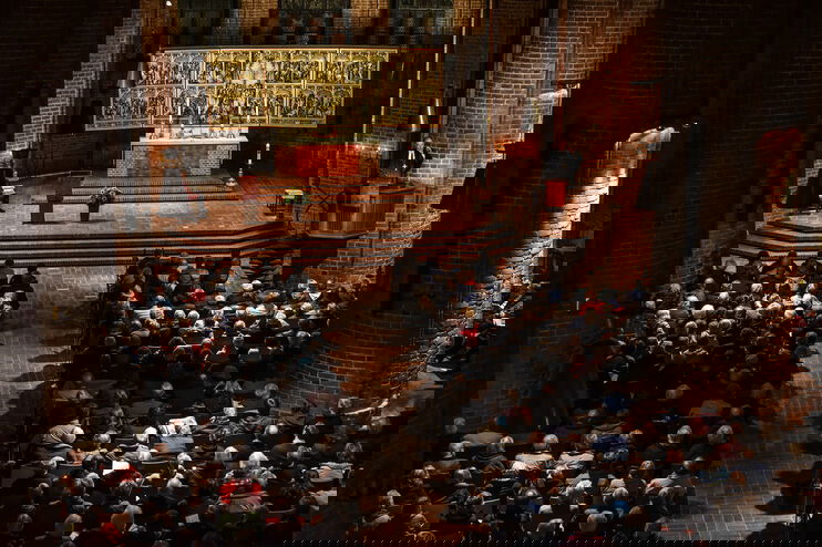 Eine Gottesdienst-Gemeinde hört einer Predigt zu.