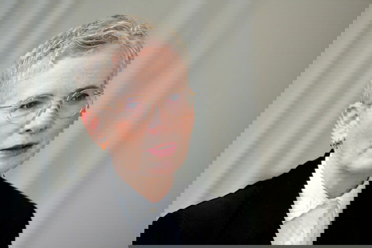 Eine als Frau lesbare Person spricht nachdenklich.