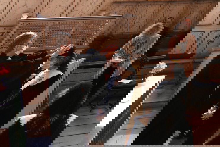 Eine weiblich gelesene Person im Talar legt die Hände auf eine jüngere, weiblich gelesene Person in Konventualinnen-Kleid. 