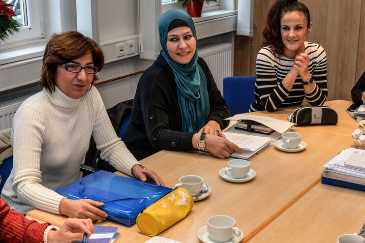 mehrere frauen sitzen an einem tisch und tauschen sich aus