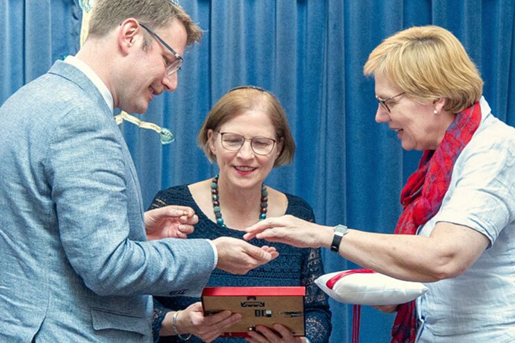 Eine Gruppe von Menschen vor einem blauen Vorhang.