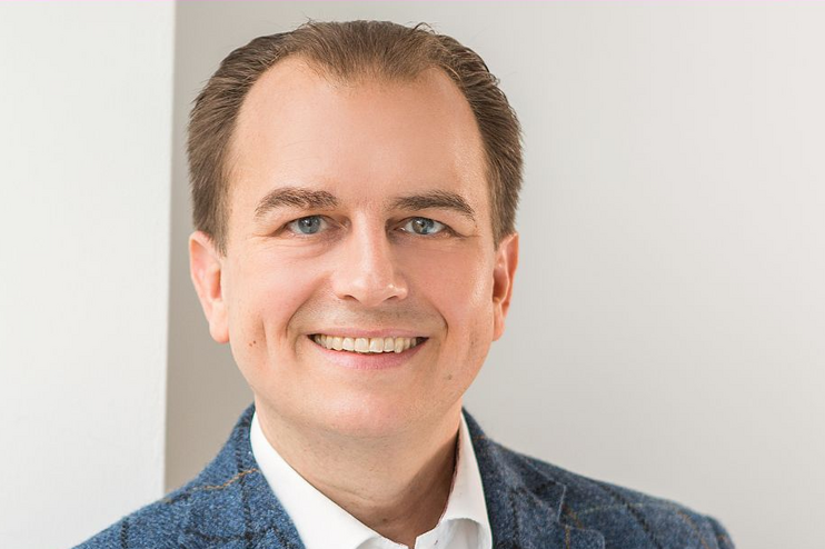 Eine männlich gelesene Person mit dunklen kurzen Haaren