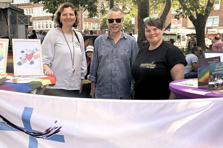 Drei Menschen stehen hinter einem Stand