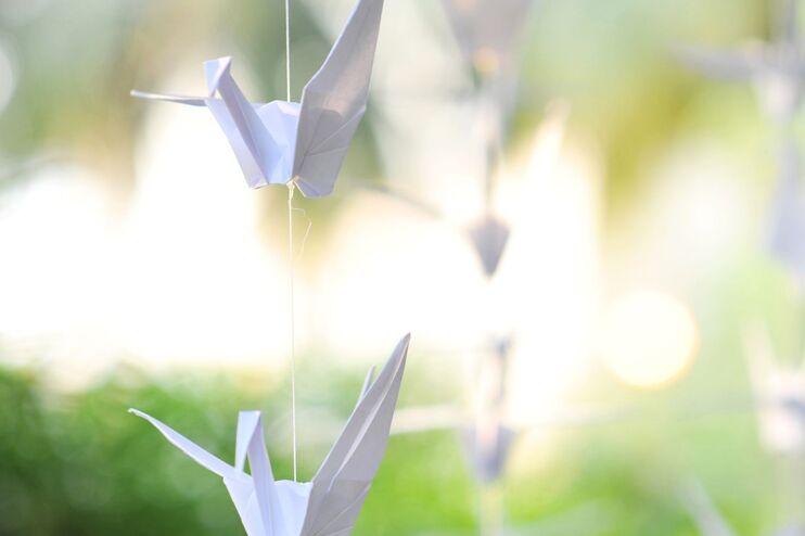 weiße Papierkraniche im Freien an einer Schnur