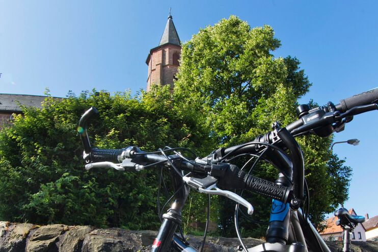 Eine Kirche vor blauem Himmel, an der Mauer lehnen Fahrräder.